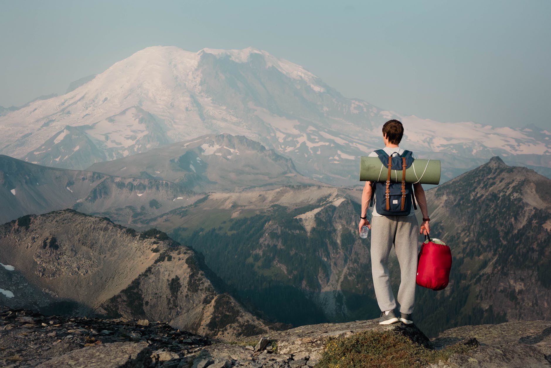 unrecognizable backpacker standing on top of mountain