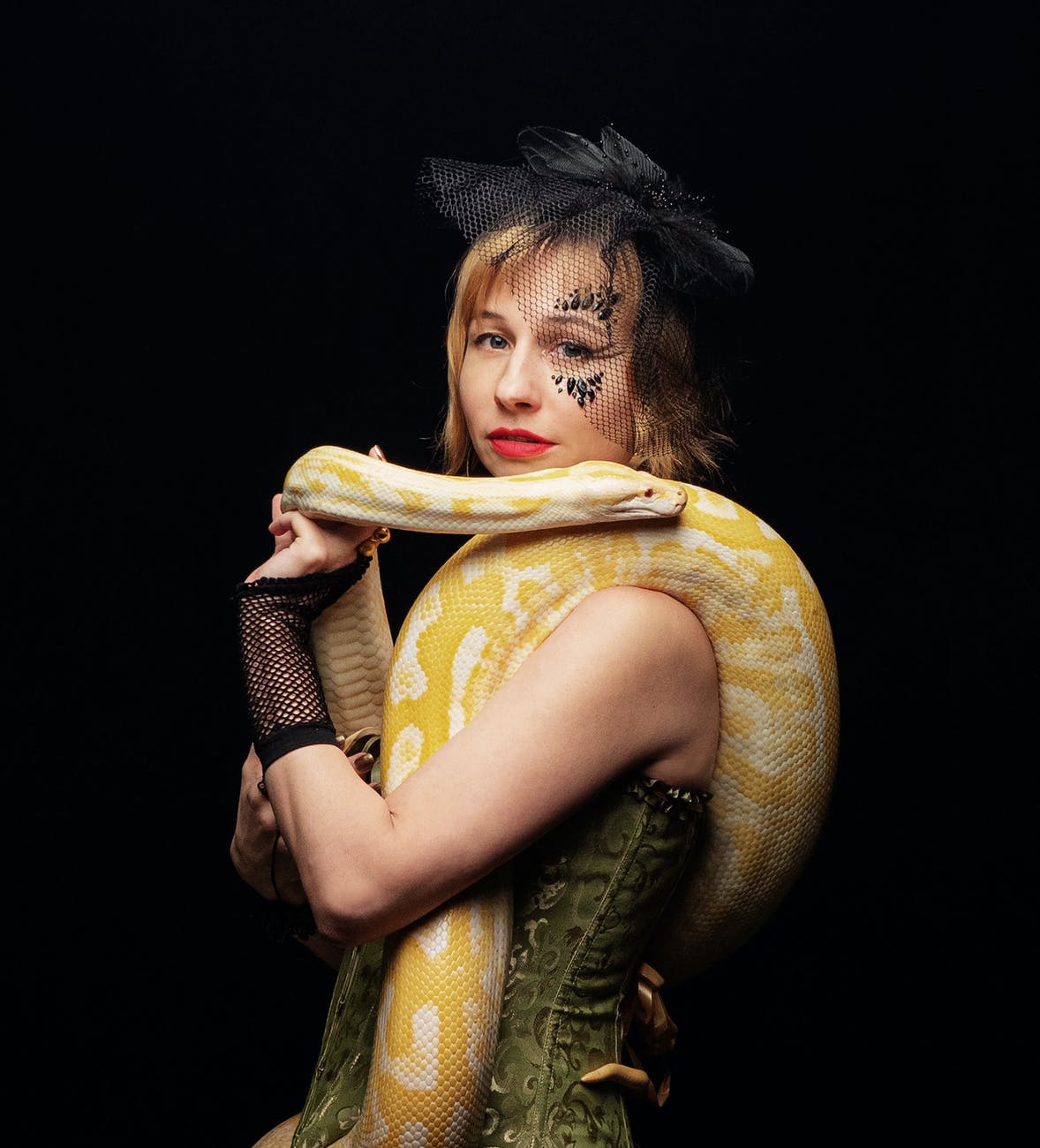woman with big live yellow snake on shoulders